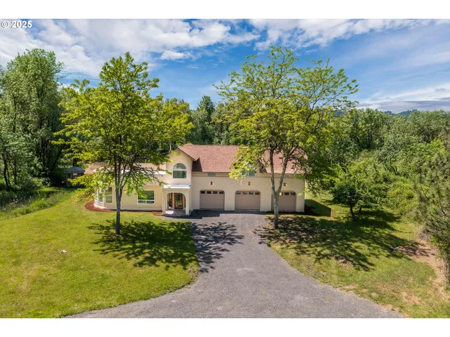 a aerial view of a house with swimming pool and large trees