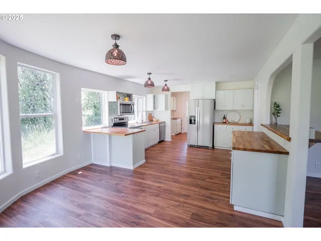 a living room with kitchen island wooden floor and kitchen view