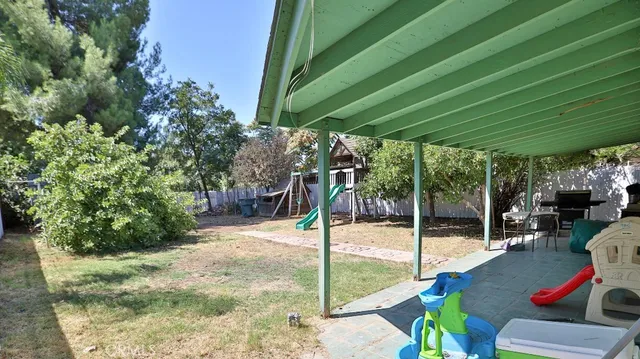 a view of a patio with table and chairs under an umbrella