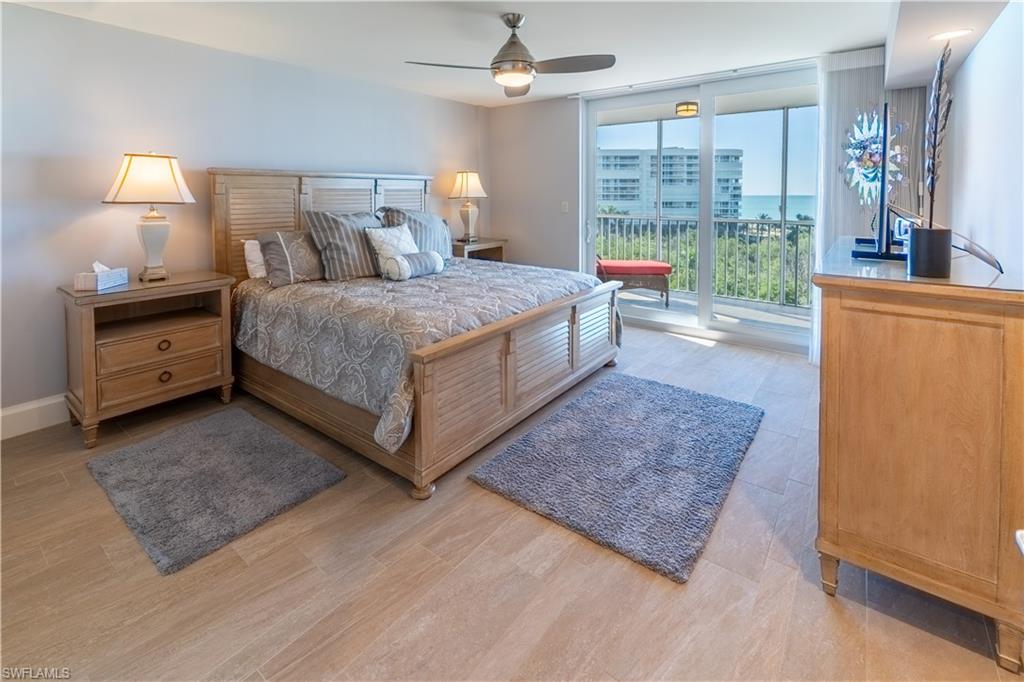 3 Bluebill Avenue, Unit 801 Naples, FL 34108 - Photo 9 of 29 a spacious bedroom with a bed a dresser and a large window