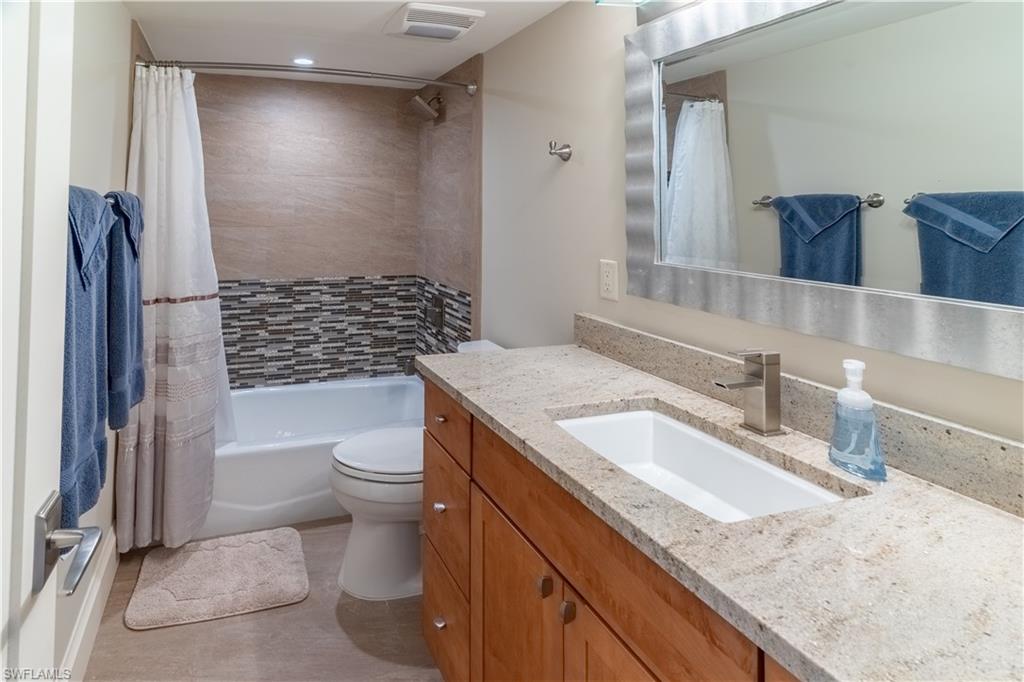 3 Bluebill Avenue, Unit 801 Naples, FL 34108 - Photo 11 of 29 a bathroom with a granite countertop toilet sink and mirror