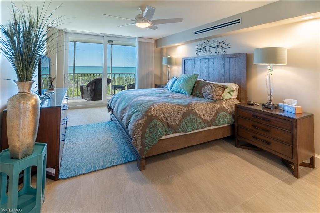 3 Bluebill Avenue, Unit 801 Naples, FL 34108 - Photo 16 of 29 a bed sitting in a room next to a window and dresser