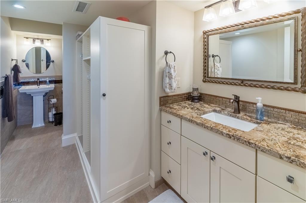 3 Bluebill Avenue, Unit 801 Naples, FL 34108 - Photo 18 of 29 a bathroom with a granite countertop sink vanity and mirror
