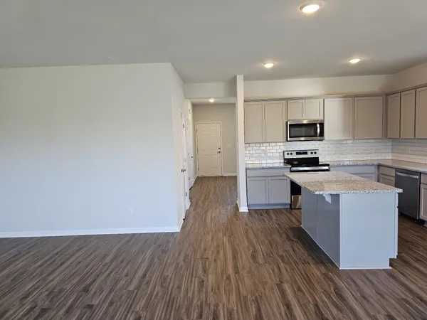 a kitchen with wooden floors and appliances