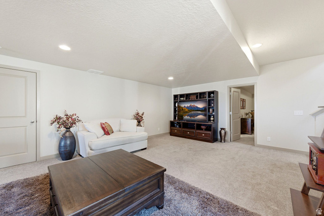 987 East Deer Arch Lane Draper, UT 84020 - Photo 33 of 46 Large basement living room featuring carpet floors, a textured ceiling, and recessed lighting