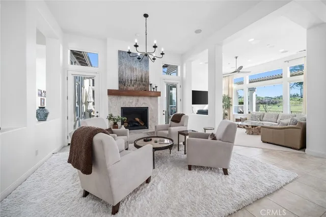 a living room with furniture a fireplace and a chandelier