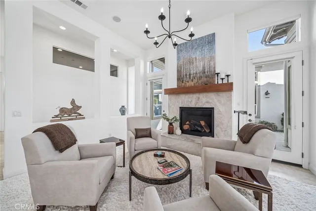 a living room with furniture a rug kitchen view and a chandelier