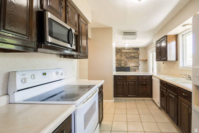 634 South 2100th Street West Vernal, UT 84078 - Photo 10 of 71 Kitchen featuring wood cabinetry, light-toned countertops, and a white electric range with an overhead stainless steel microwave