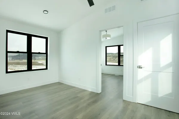 an empty room with wooden floor and a window