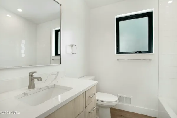 a bathroom with a toilet sink and mirror