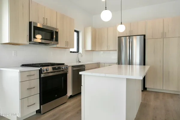 a kitchen with stainless steel appliances a stove microwave and a refrigerator