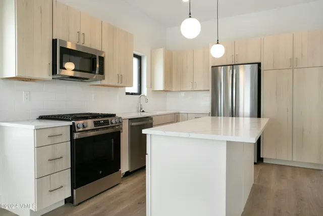 a kitchen with stainless steel appliances a stove microwave and a refrigerator