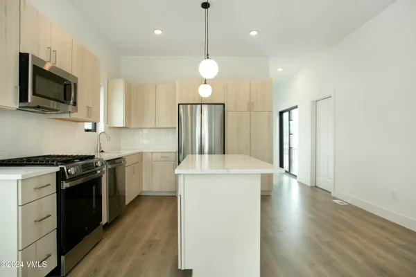 a kitchen with stainless steel appliances granite countertop a stove a sink and a refrigerator