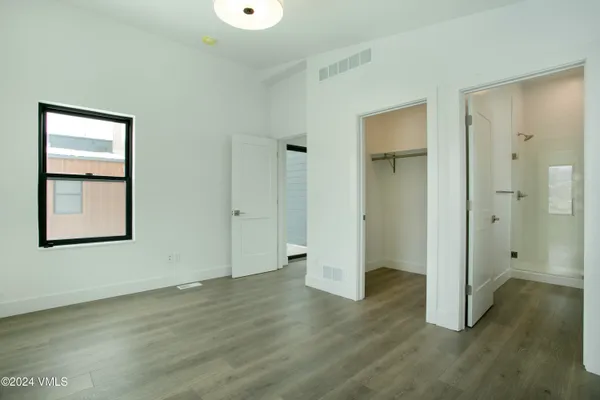 an empty room with wooden floor and mirror