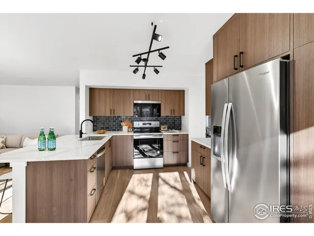 a kitchen with stainless steel appliances a refrigerator sink and stove