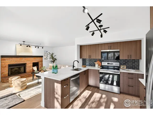 a kitchen with stainless steel appliances kitchen island granite countertop a refrigerator and a stove top oven