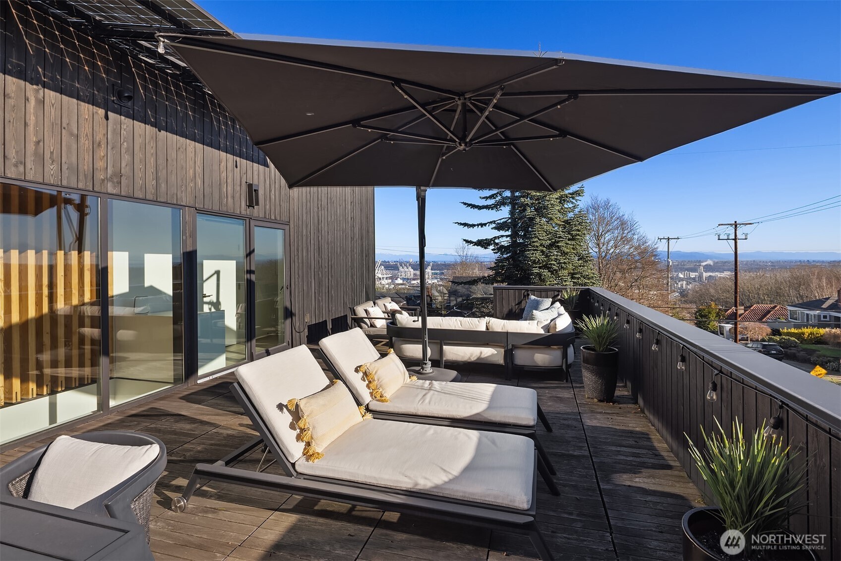 3057 36th Avenue Southwest Seattle, WA 98126 - Photo 18 of 40 a view of a roof deck with table and chairs under an umbrella