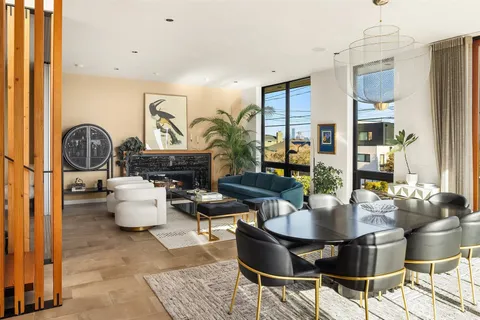 a dining room with furniture a chandelier and wooden floor