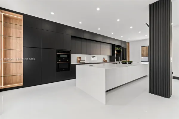 a large kitchen with stainless steel appliances lots of counter space and a sink