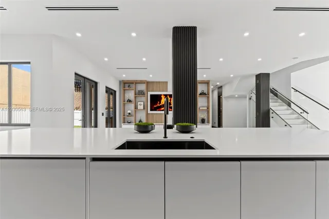 a large white kitchen with wooden floors and stainless steel appliances