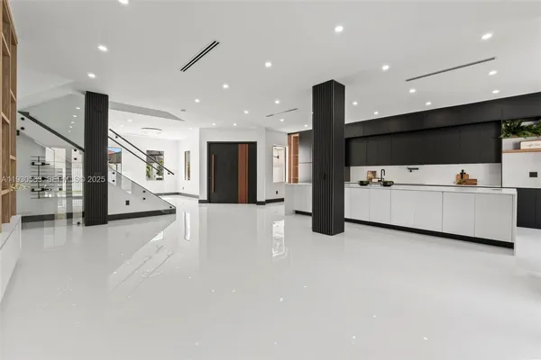 a living room with stainless steel appliances kitchen island furniture wooden floor and a large window