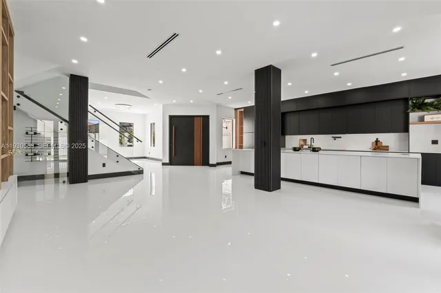 a living room with stainless steel appliances kitchen island furniture wooden floor and a large window