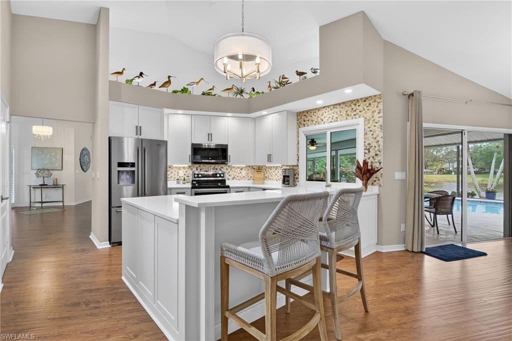2248 Prince Lane Naples, FL 34112 - Photo 11 of 47 a living room with kitchen island furniture and a chandelier