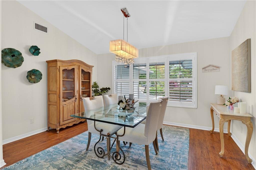 2248 Prince Lane Naples, FL 34112 - Photo 10 of 47 a dining room with furniture a chandelier and wooden floor