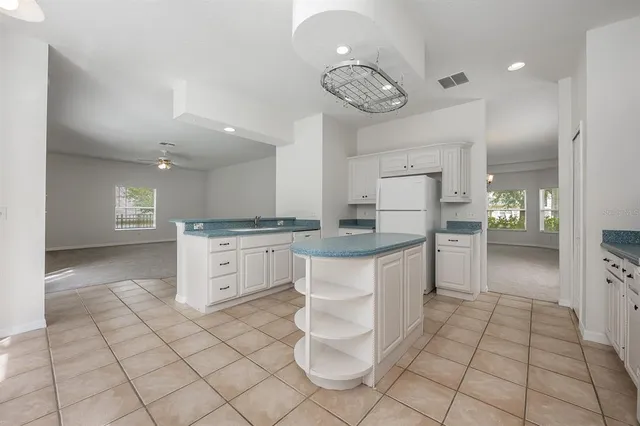 a kitchen with white cabinets appliances and a fireplace