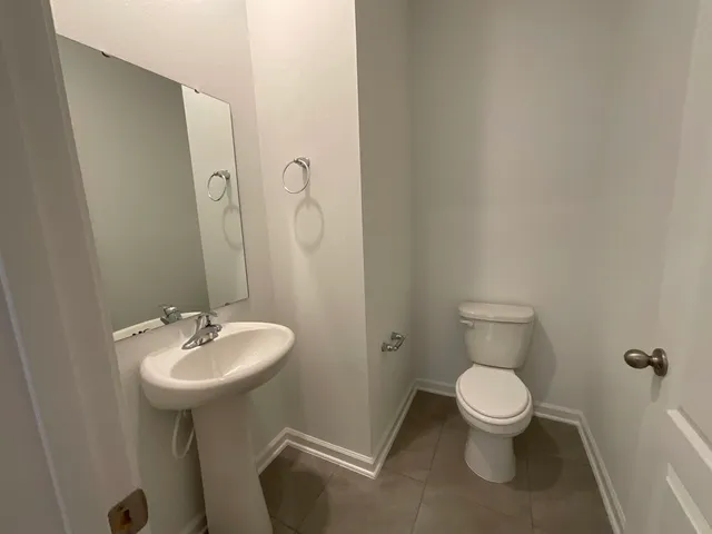 a bathroom with a sink a toilet and mirror