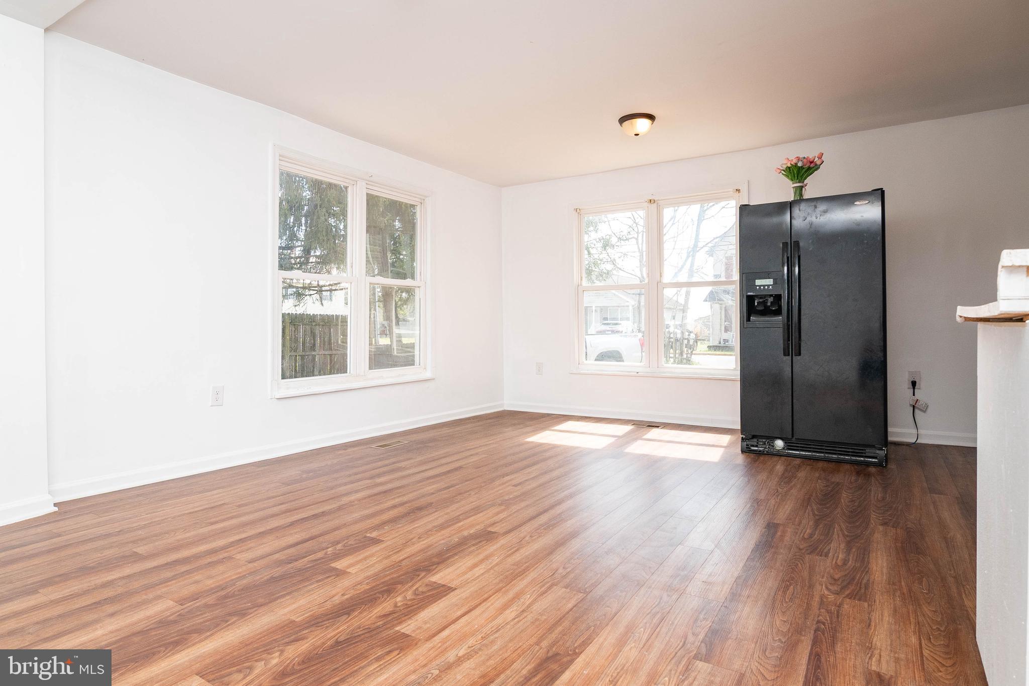 235 West 10th Street Laurel, DE 19956 - Photo 12 of 44 an empty room with wooden floor and windows