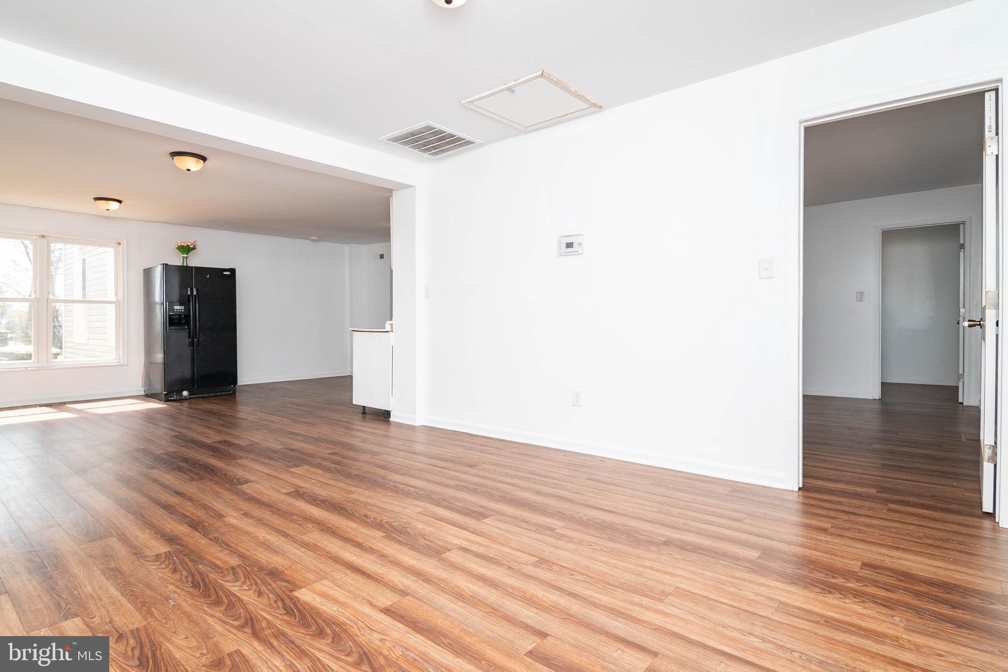 235 West 10th Street Laurel, DE 19956 - Photo 13 of 44 a view of an empty room with wooden floor and a window