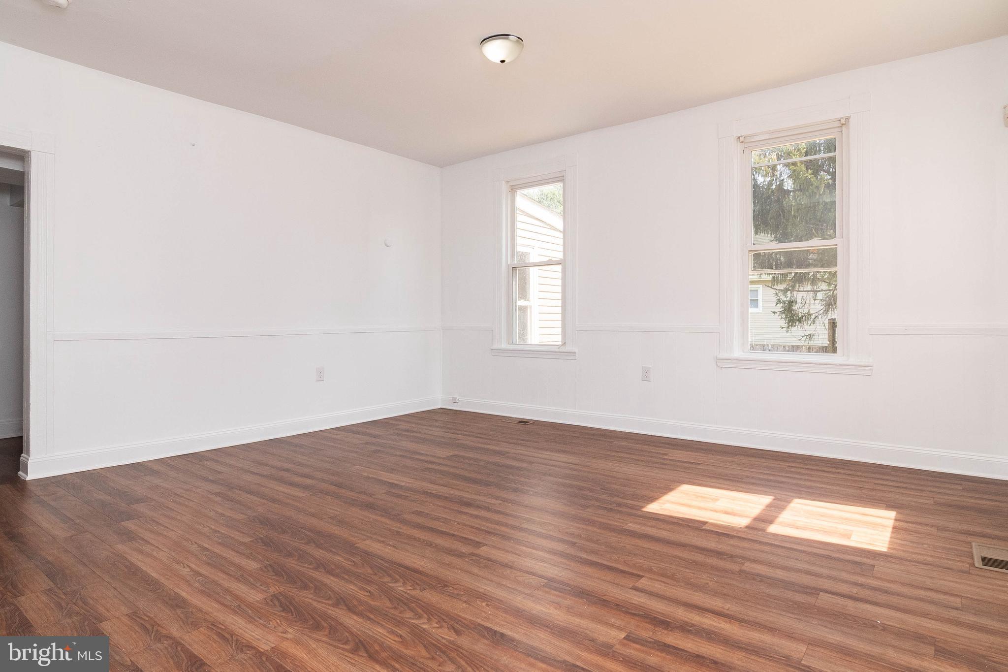 235 West 10th Street Laurel, DE 19956 - Photo 14 of 44 an empty room with wooden floor and windows