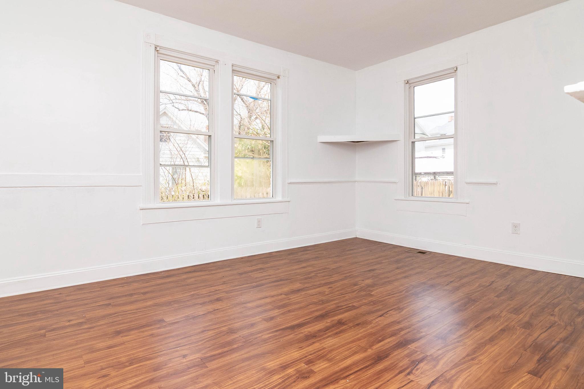 235 West 10th Street Laurel, DE 19956 - Photo 19 of 44 an empty room with wooden floor and windows
