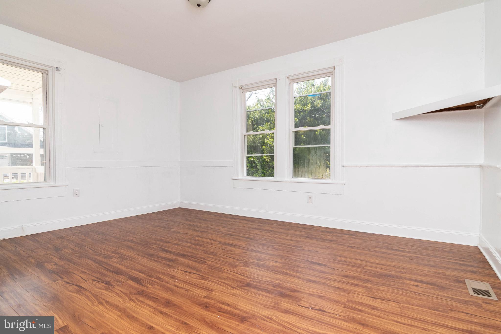 235 West 10th Street Laurel, DE 19956 - Photo 20 of 44 an empty room with wooden floor and windows