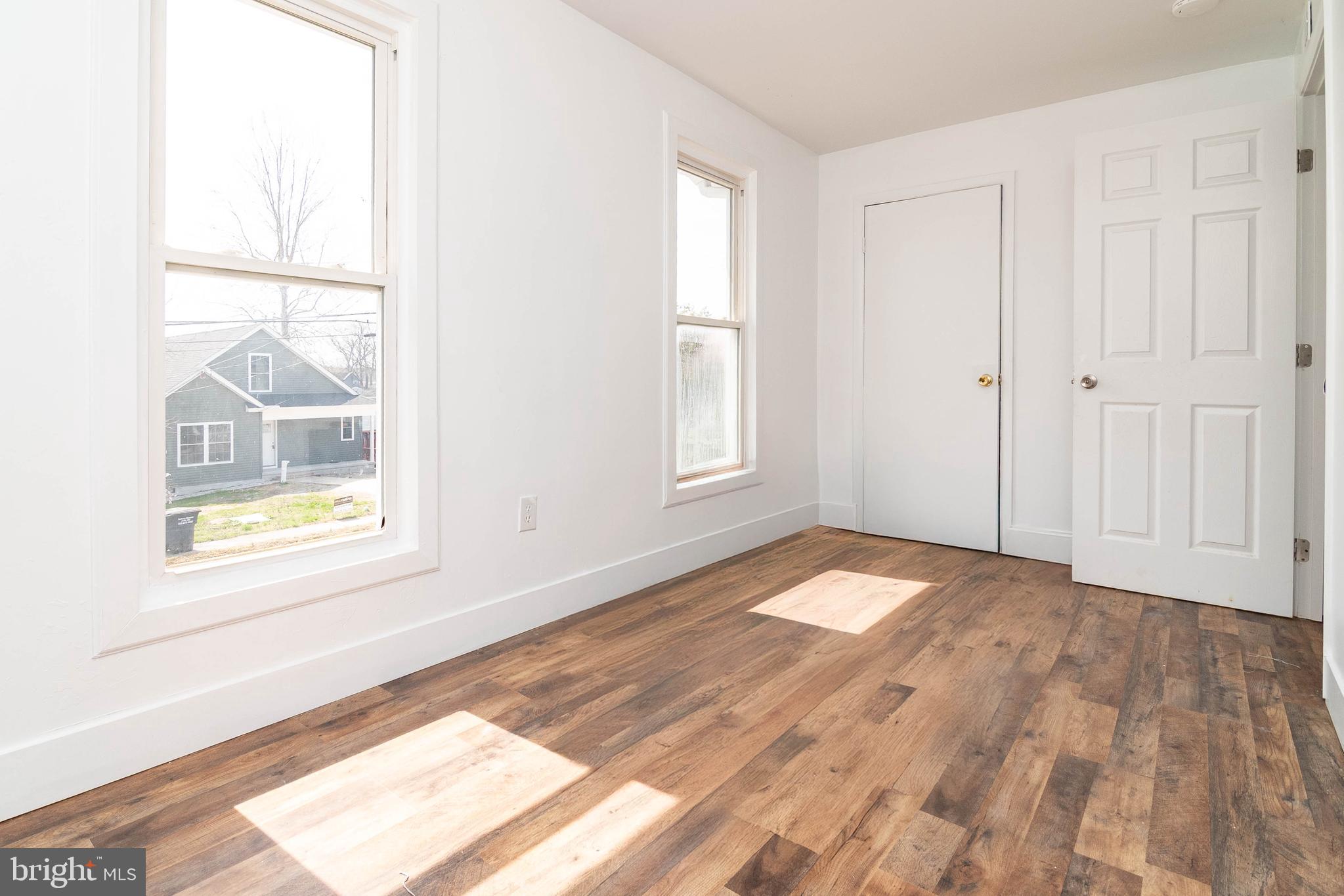 235 West 10th Street Laurel, DE 19956 - Photo 21 of 44 an empty room with wooden floor and windows
