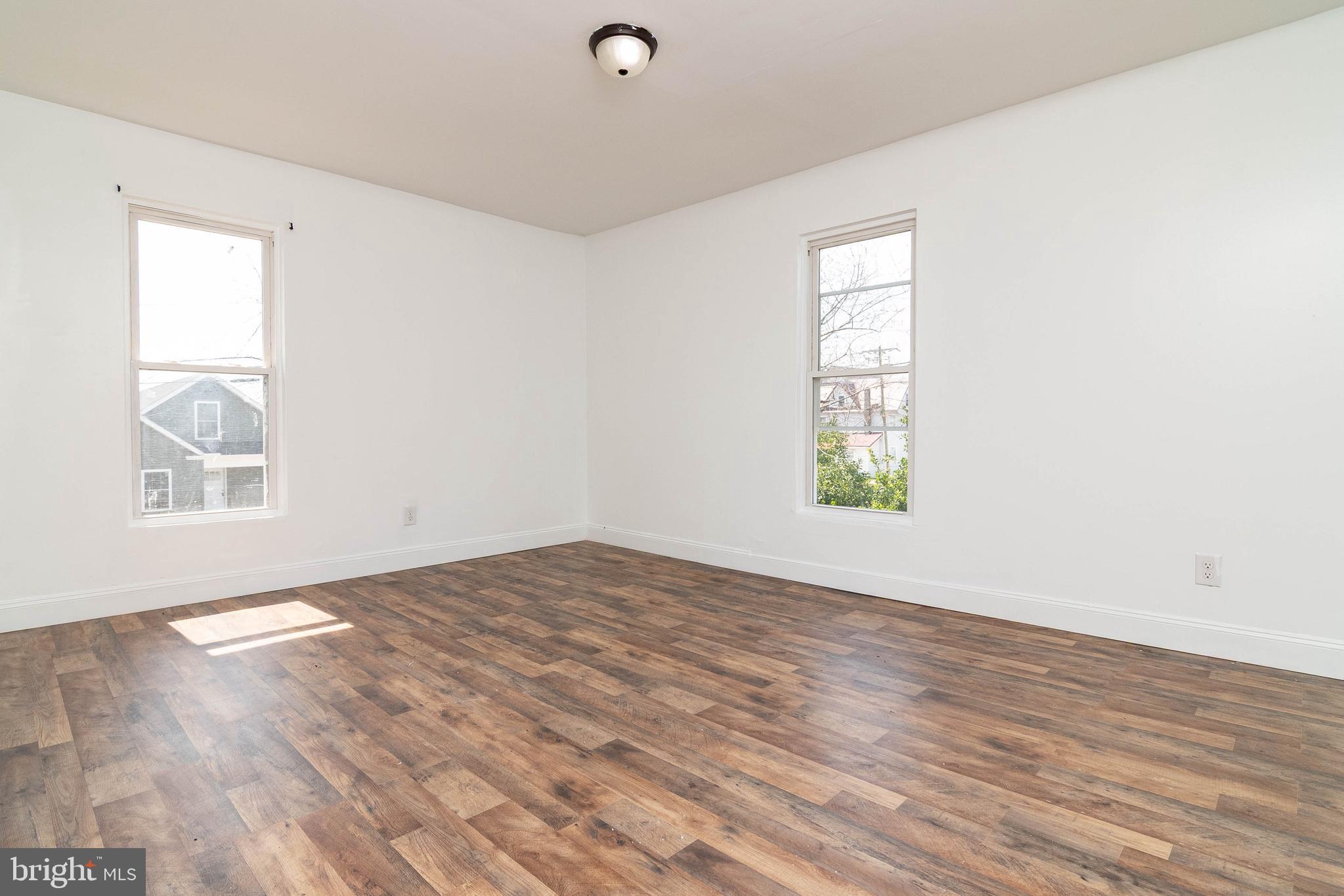 235 West 10th Street Laurel, DE 19956 - Photo 23 of 44 an empty room with wooden floor and windows