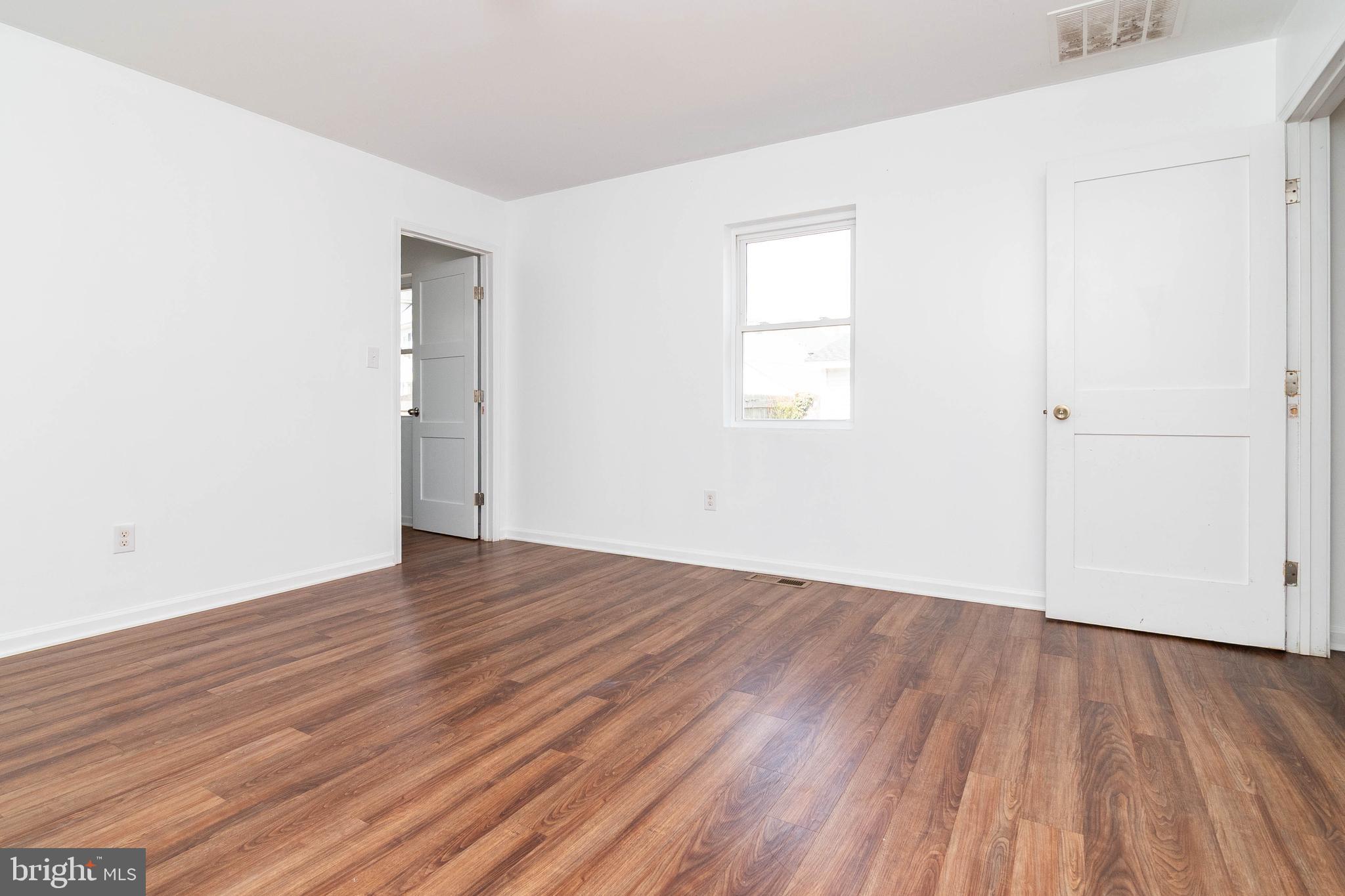 235 West 10th Street Laurel, DE 19956 - Photo 25 of 44 an empty room with wooden floor and windows