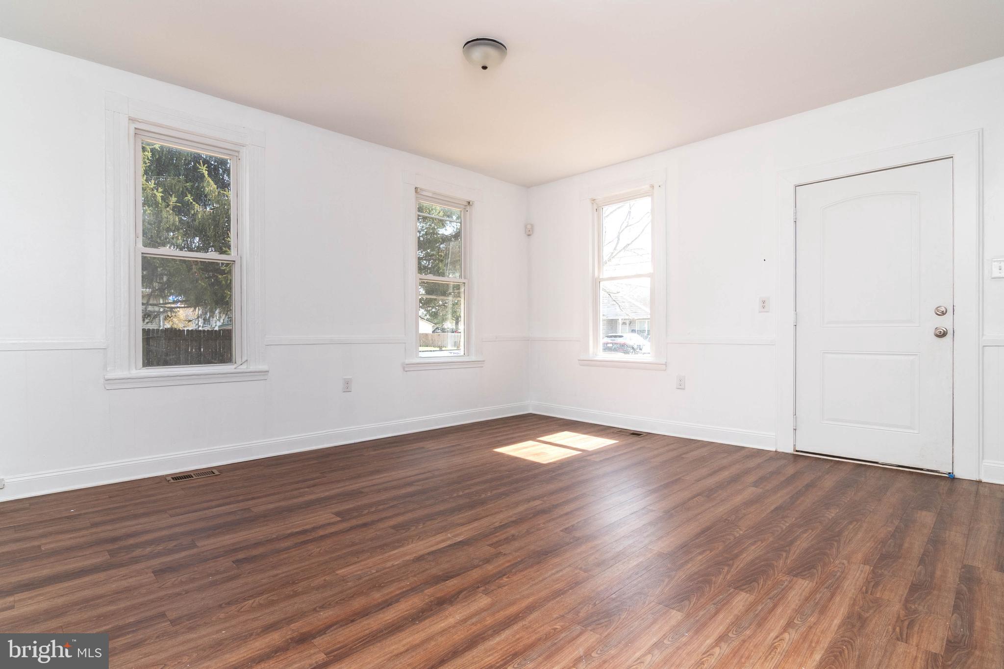 235 West 10th Street Laurel, DE 19956 - Photo 4 of 44 a view of an empty room with wooden floor and a window