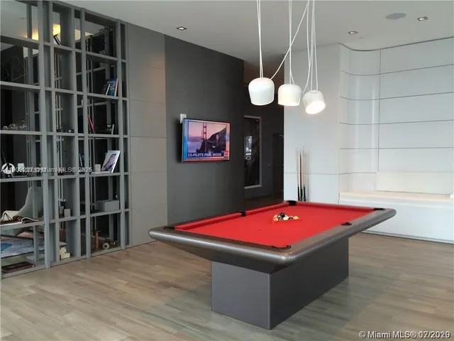 a room with pool table and a bookshelf
