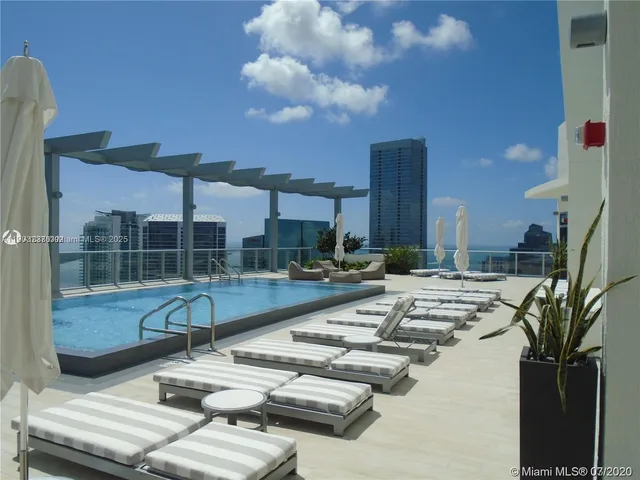 a view of swimming pool with outdoor seating and city view