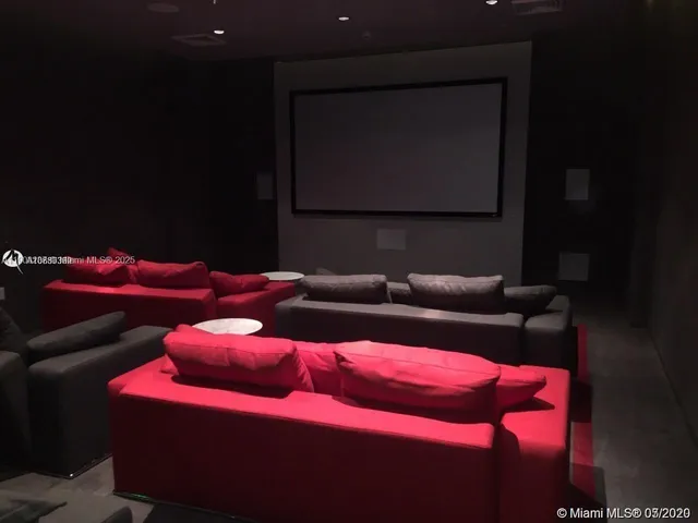 a projector room with furniture and a flat screen tv
