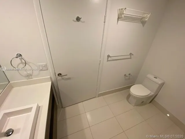 a bathroom with a granite countertop toilet and a sink