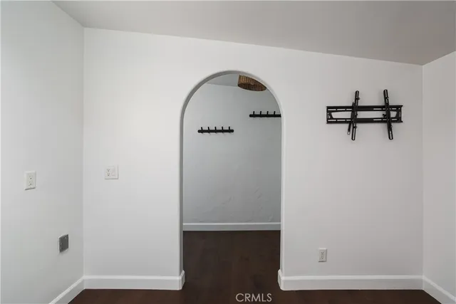 a view of a patio with table and chairs under an umbrella with a fire pit and large trees