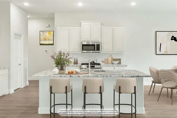 a kitchen with granite countertop white cabinets and stainless steel appliances