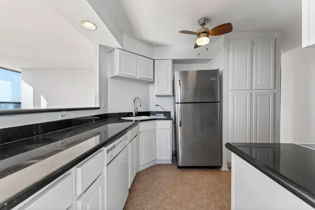 a kitchen with white cabinets and stainless steel appliances