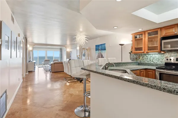 a kitchen with stainless steel appliances granite countertop a sink stove and refrigerator