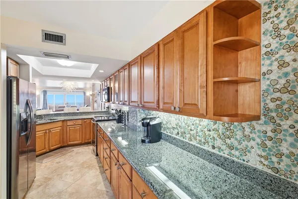 a kitchen with granite countertop a sink and a wooden cabinets