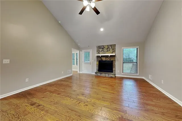 wooden floor fireplace and windows in an empty room