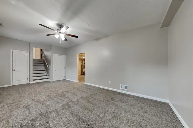 an empty room with windows and ceiling fan